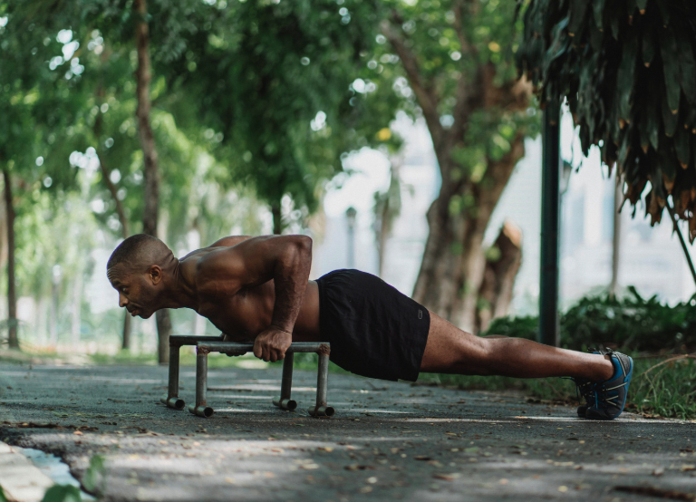 Man in black shorts doing pushups outside
