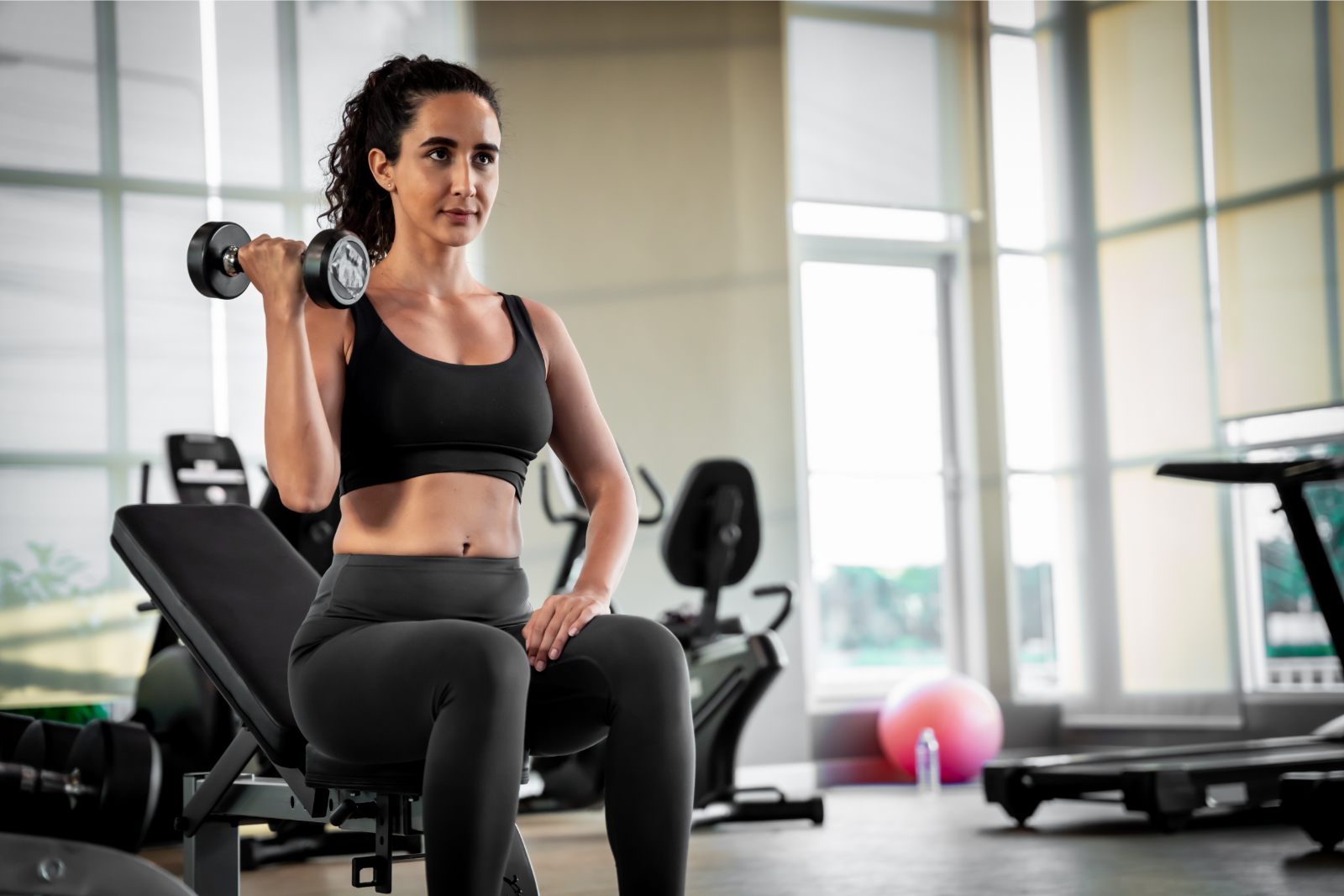 woman on bench lifting dumbell